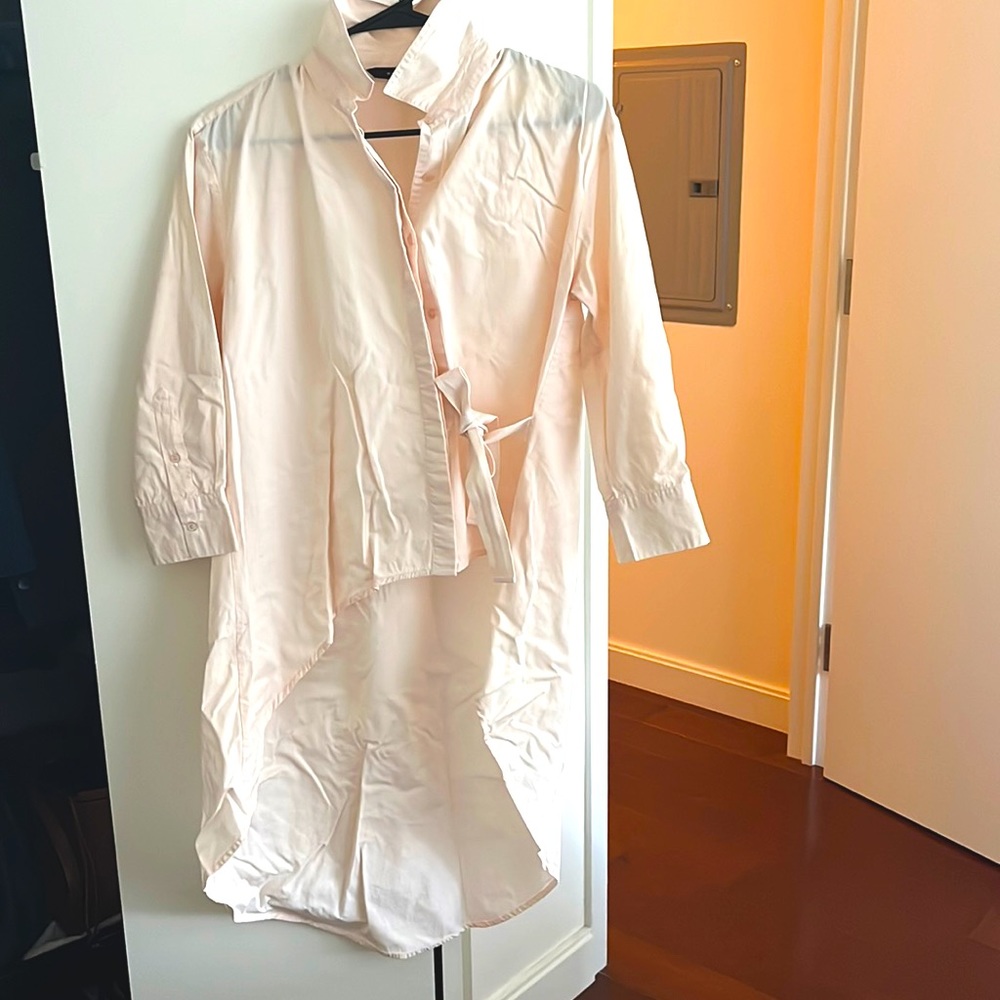 A dressy asymmetric shirt in light salmon color& a ribbon detailing on the front
